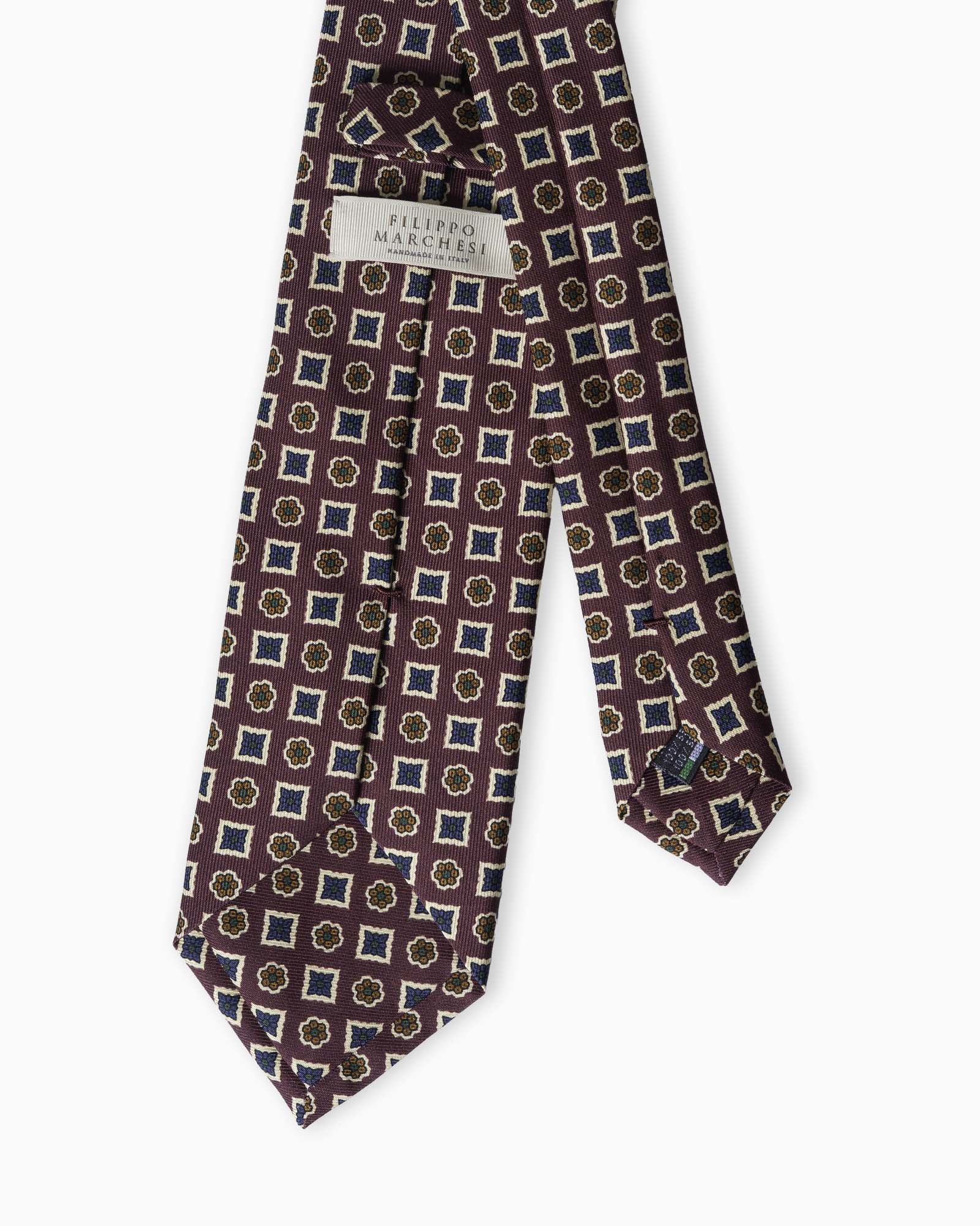 Cravatta artigianale in seta madder bordeaux con elegante motivo geometrico floreale e lavorazione tre pieghe Made in Italy